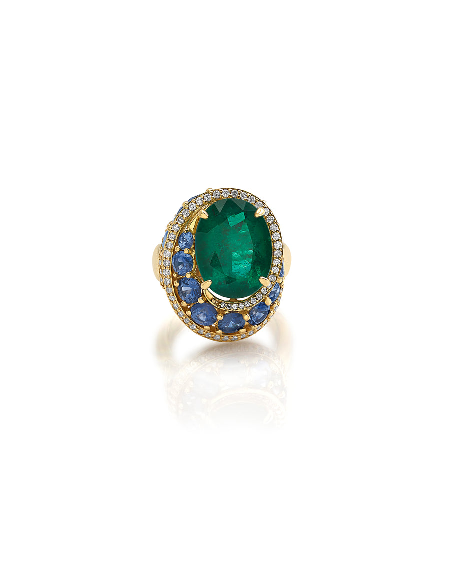 Ring in 18kt yellow gold set with white diamonds (0.66 cts), blue sapphires (4.86 cts), and one oval shape emerald center stone (7.46 cts)