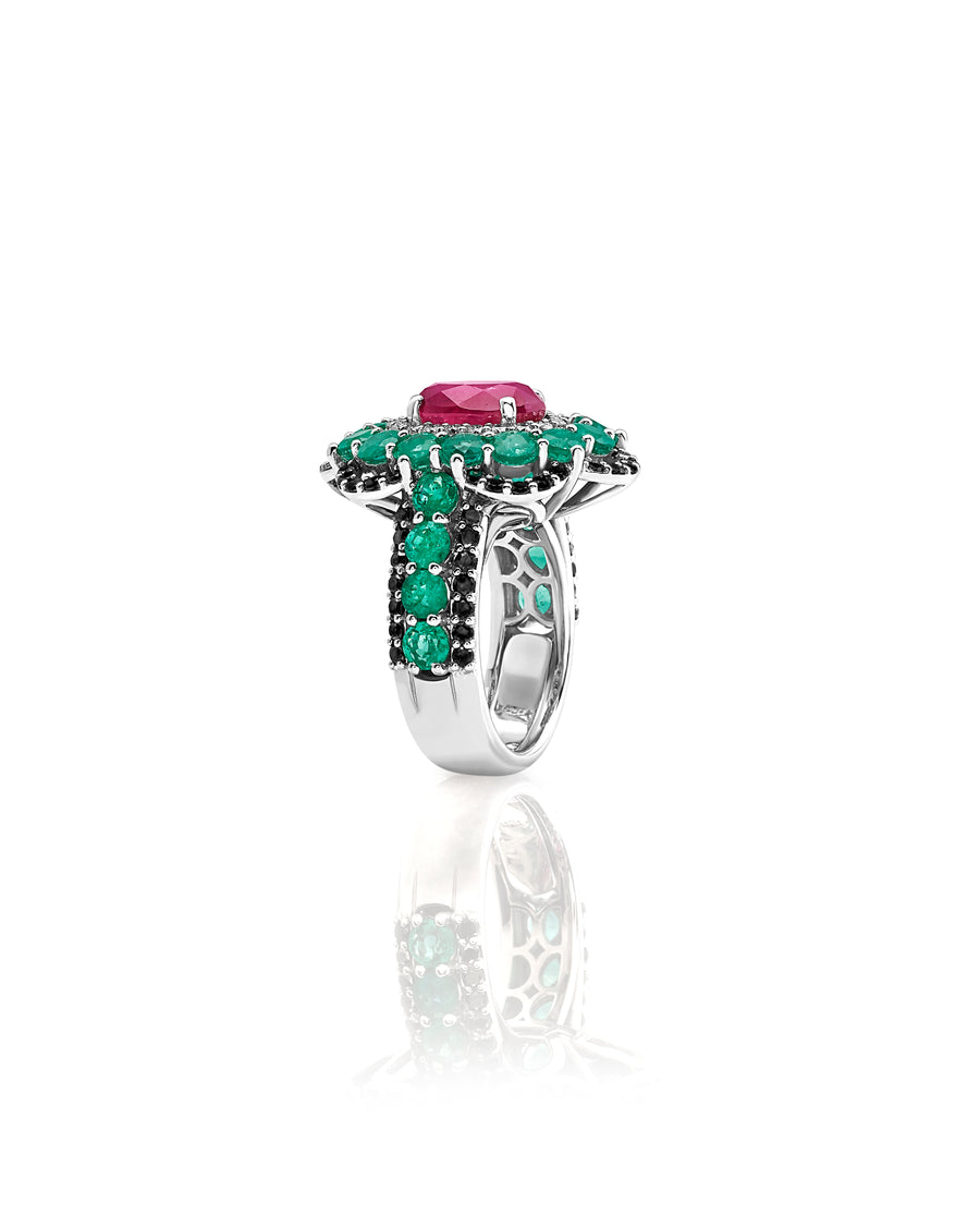 Ring in 18kt white gold set with white diamonds (0.34 cts), black diamonds (1.04 cts), emeralds (3.83), and oval shape ruby center stone (4.03 cts)